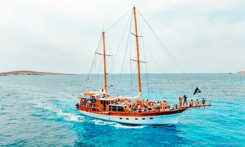 Boat passing the sea caves on Comino's coastline