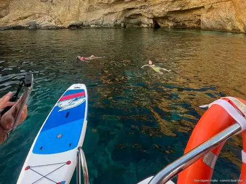 Passengers paddleboarding at the Crystal Lagoon swim stop on the Cirkewwa tour